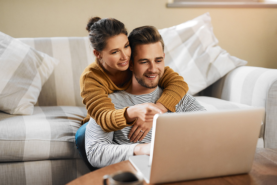 Uma mulher e um homem a verificar algo num portátil